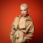 A woman in a trench coat posing for a picture