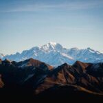 a mountain range with snow capped mountains in the background