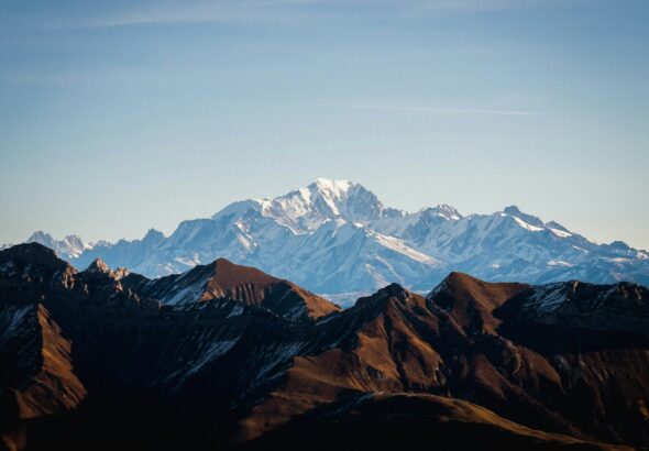 a mountain range with snow capped mountains in the background